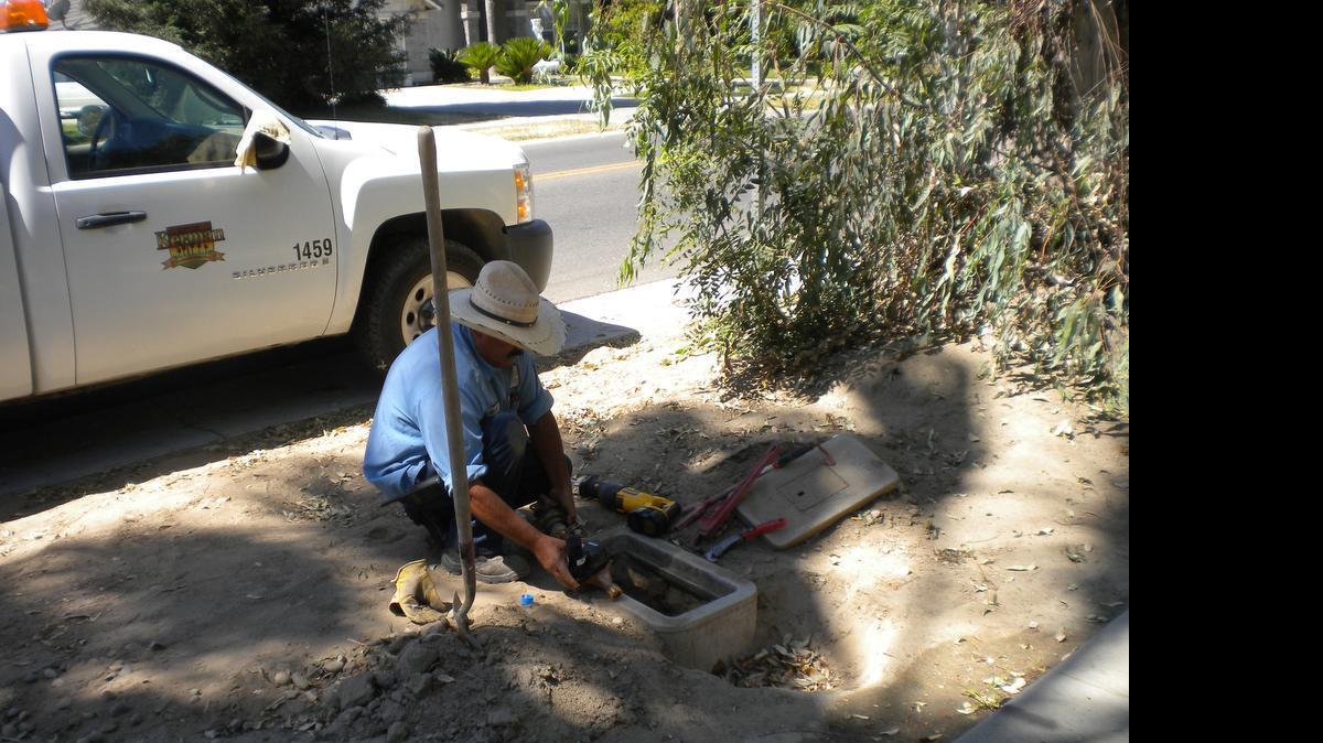 
City employee Manuel Ramirez installs a water meter in Kerman.
