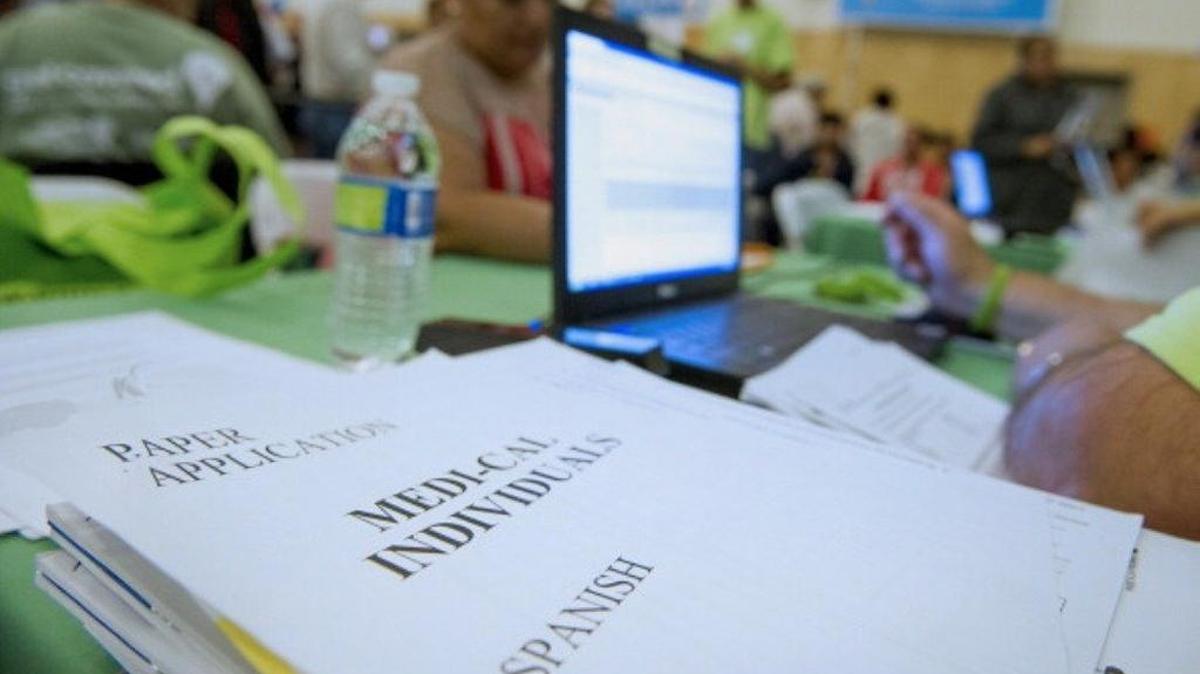 Applications for Medi-Cal health insurance sit on a table during a WeConnect event in Oakland in 2013.