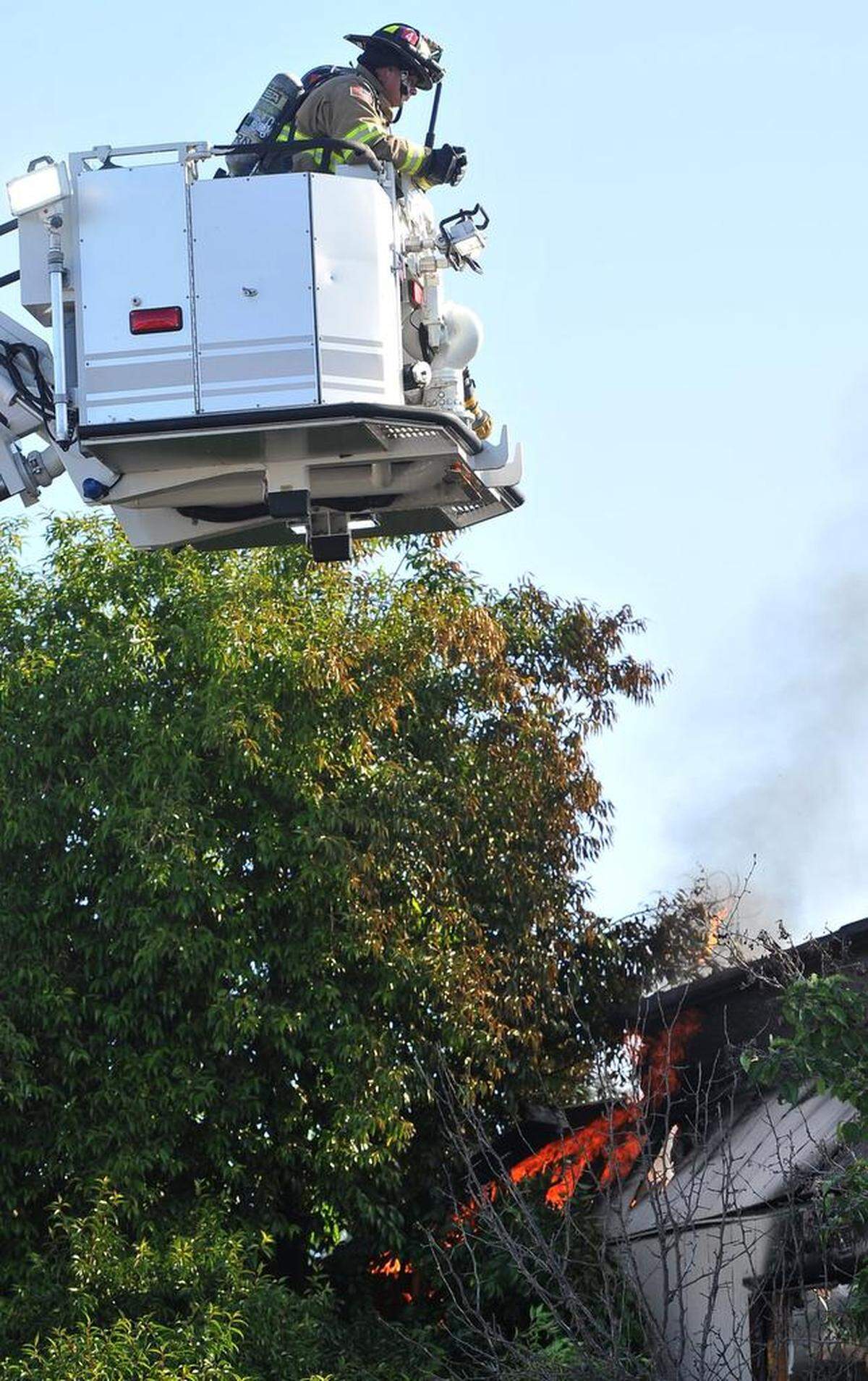 A Fresno Fire Department ladder crew keeps an eye on flames from an apartment fire after controlling the burn, on McKinley and Normal avenues, Monday morning, May 7, 2018.
