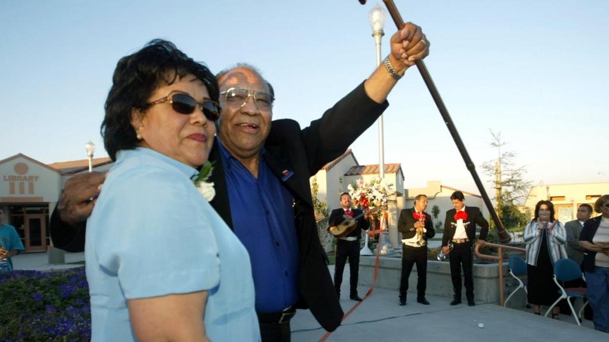 2004: Ben Benavídez stands next to his wife, Gloria Benavídez, and raises his cane in celebration as Mariachi De La Tierra, background, begins to play during the official ribbon cutting ceremony for the new S. Ben Benavídez Elementary School in Parlier. Between 300 and 400 people including dignitaries came for congratulatory speeches, music and food.