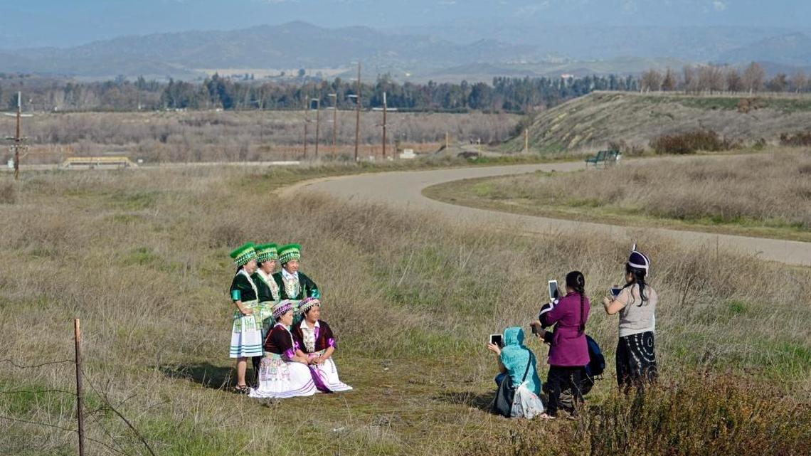 A group of women wearing traditional Hmong clothing are photographed near the Eaton Trail along Friant Road in north Fresno on a pleasant winter afternoon Sunday, Jan. 3, 2016. A series of storms is queued up over the Pacific Ocean waiting to drench California over the coming week.