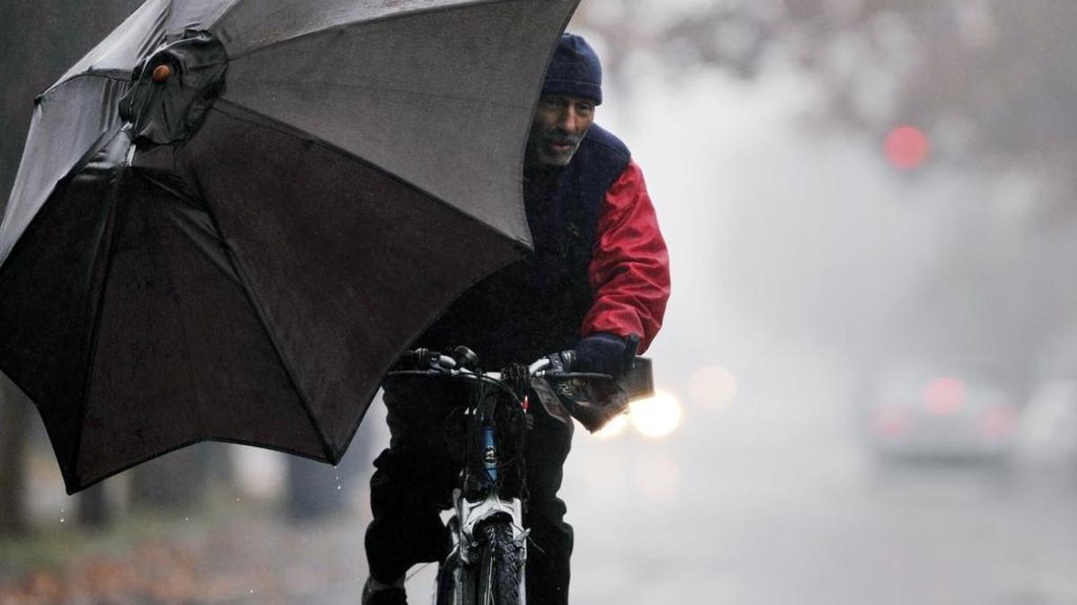 Ricky Sapien, formerly homeless, rides through the rain on Thursday, Dec. 10, 2015, toward the Salvation Army to receive food handouts. A storm arrived Thursday morning, bringing rain to the Valley and snow to the Sierra.