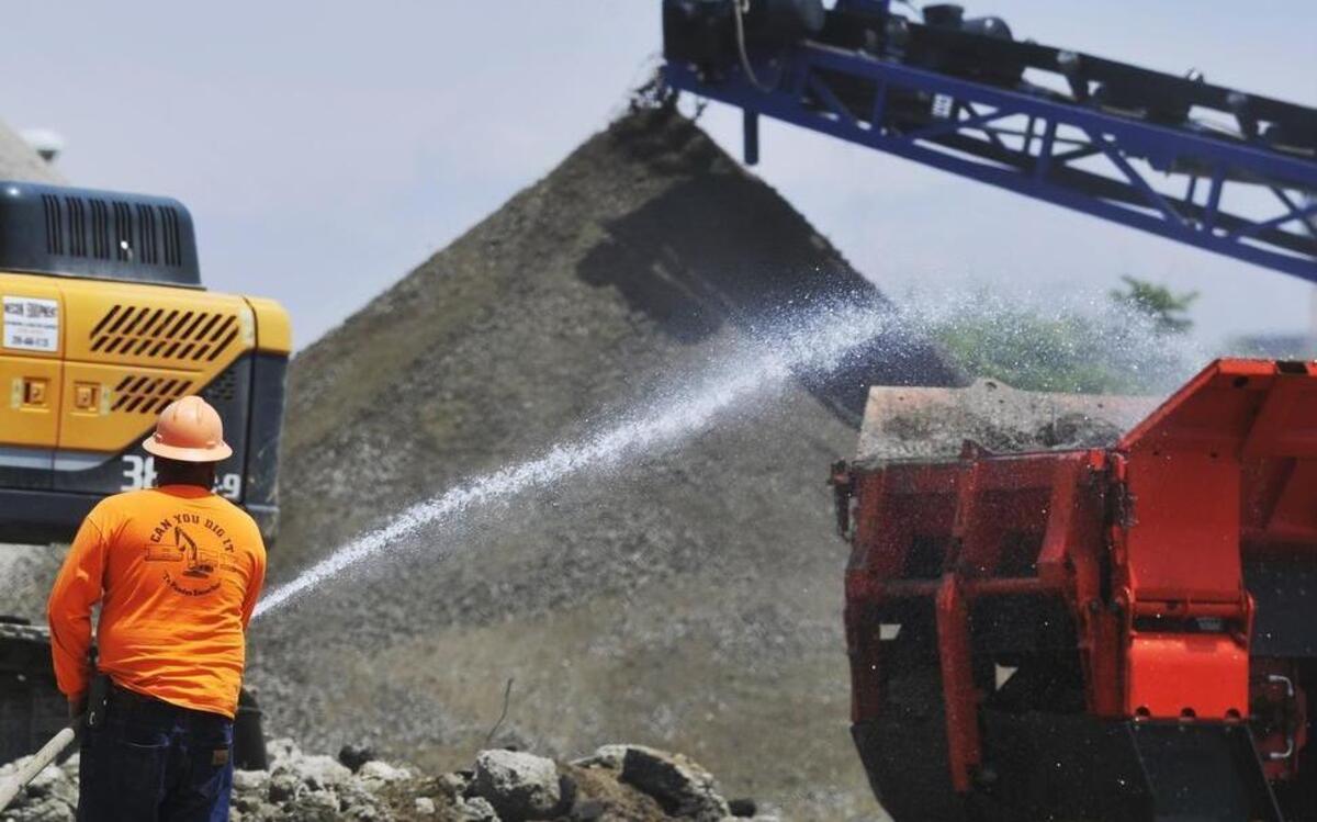 
A demolition company worker uses potable water from a city hydrant at Stanislaus and E streets to keep dust levels low on Friday, May 15, 2015 in Fresno, Calif. The city, wanting to conserve potable water, might require construction and demolition companies to go to the city's wastewater treatment plant to get extracted water for dust control during projects.
