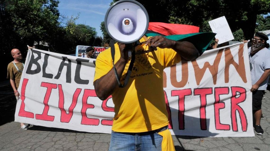 The Reverend Dr. Floyd Harris Jr., center, leads about 60 people in a march through the New Light For New Life Church Of God neighborhood for a rally in west Fresno Saturday morning, Aug. 15, 2015. About 70 people marched and rallied calling an end to police violence and supporting the Black and Brown Lives Matter movements.