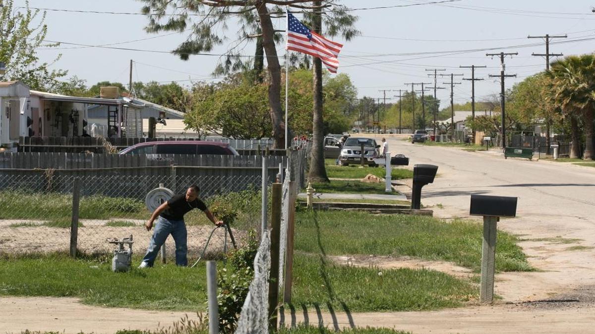 A Matheny Tract resident shuts off his hose in the front yard on Beacon Avenue just outside the city limits of Tulare. This area is an incorporated area and suffers from lack of clean drinking water.