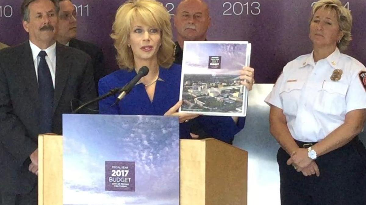 Fresno Mayor Ashley Swearengin, center, holds up the proposed 2016-17 city budget, flanked by City Manager Bruce Rudd, from left, Police Chief Jerry Dyer and Fire Chief Kerri Donis.