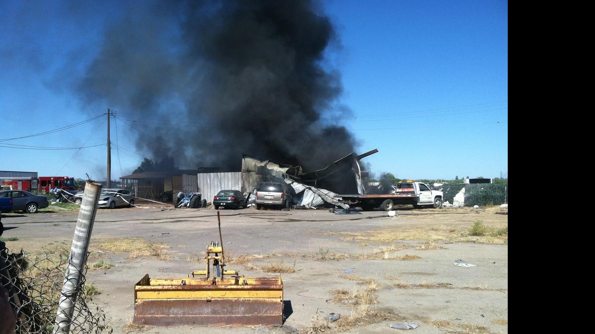 
A commercial building in a compound on Elm Avenue south of Central Avenue in Fresno County burns Saturday morning, July 25, 2015.

