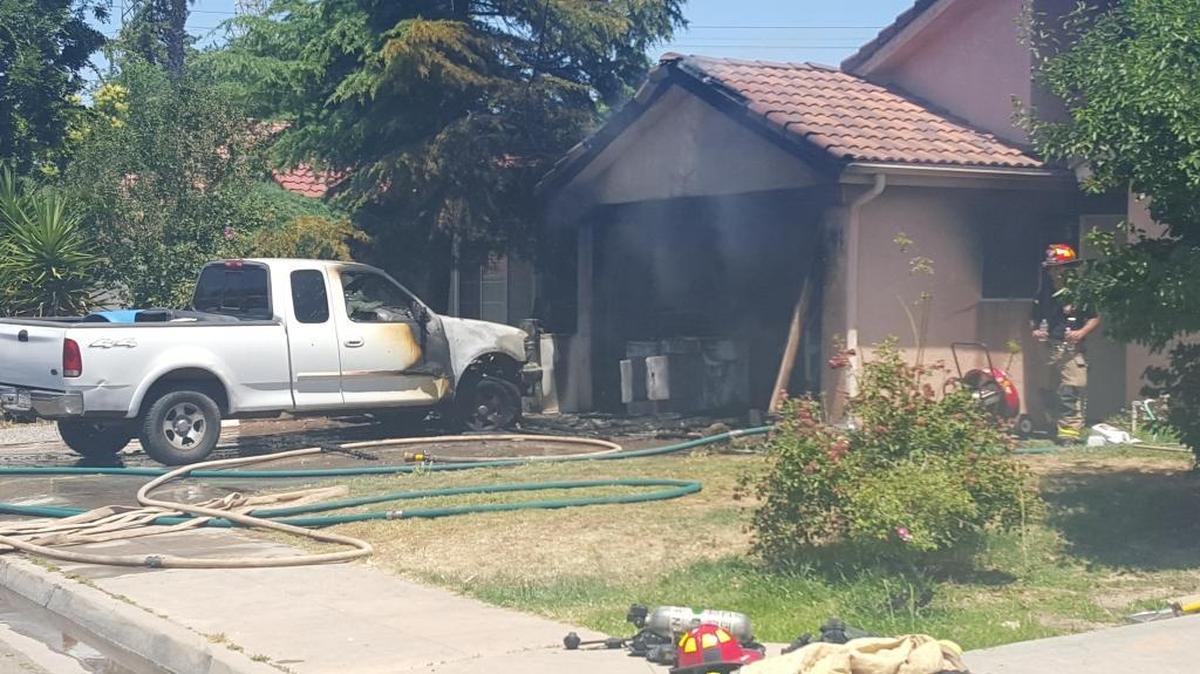 Fresno firefighters extinguish a house fire in central Fresno on Wednesday that destroyed a family’s garage and pickup.