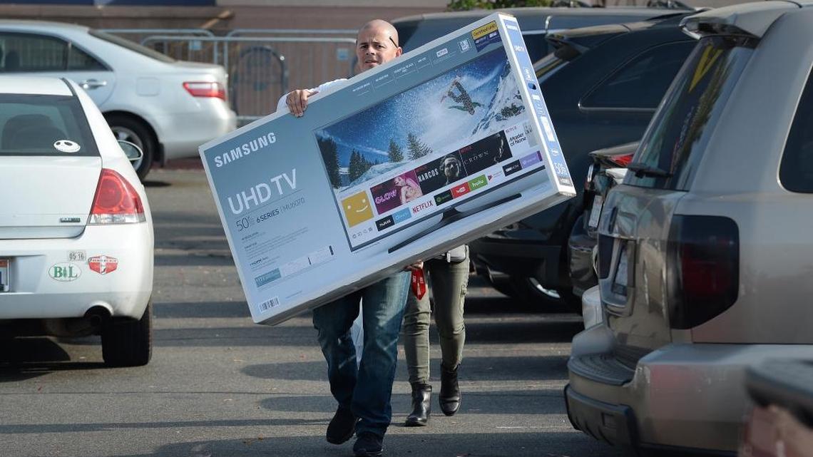Rudy Marquez of Fresno carries a TV he bought at Best Buy in the River Park shopping center while taking advantage of Black Friday deals on Friday, Nov. 24, 2017.