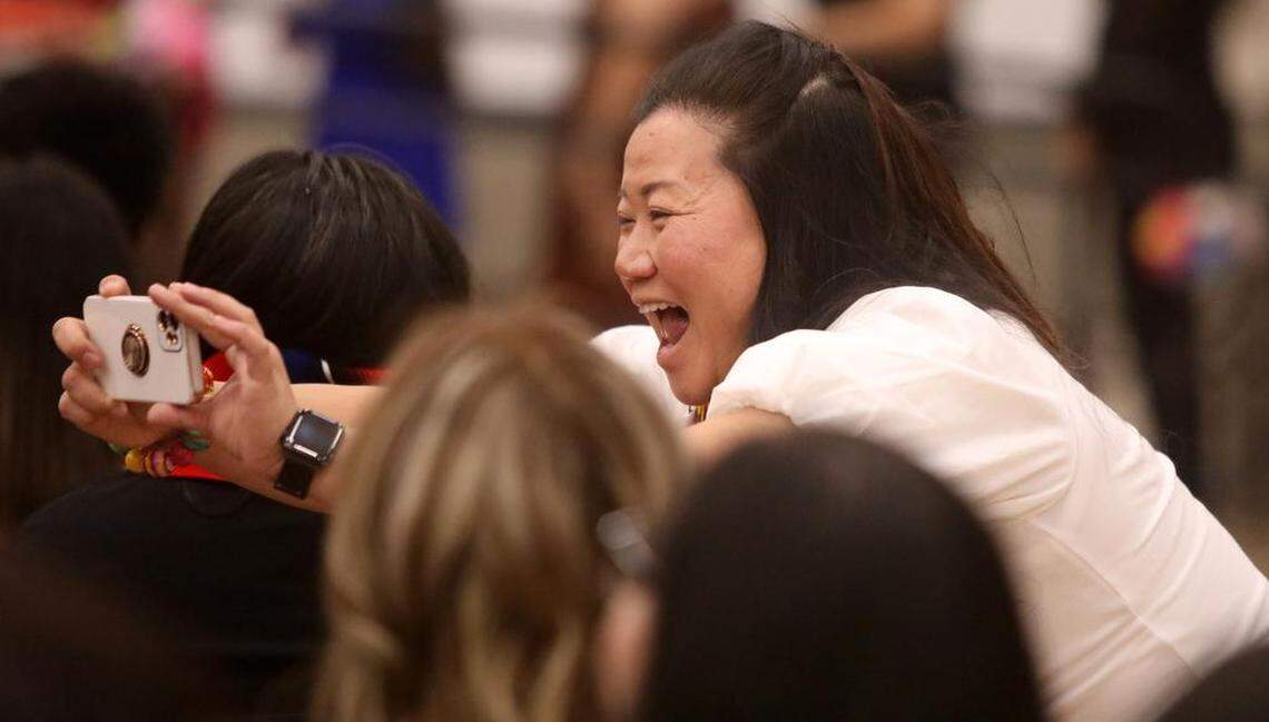 A volunteer snaps a cellphone photo of the graduates during the 21st Latino Graduation Celebration at the college gym on May 6, 2023.