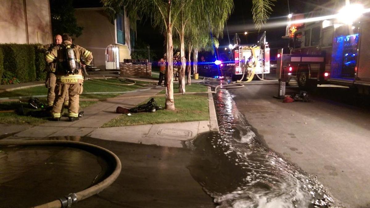 Fresno fire crews work a three-alarm apartment fire in southeast Fresno Tuesday night, Oct. 27, 2015.