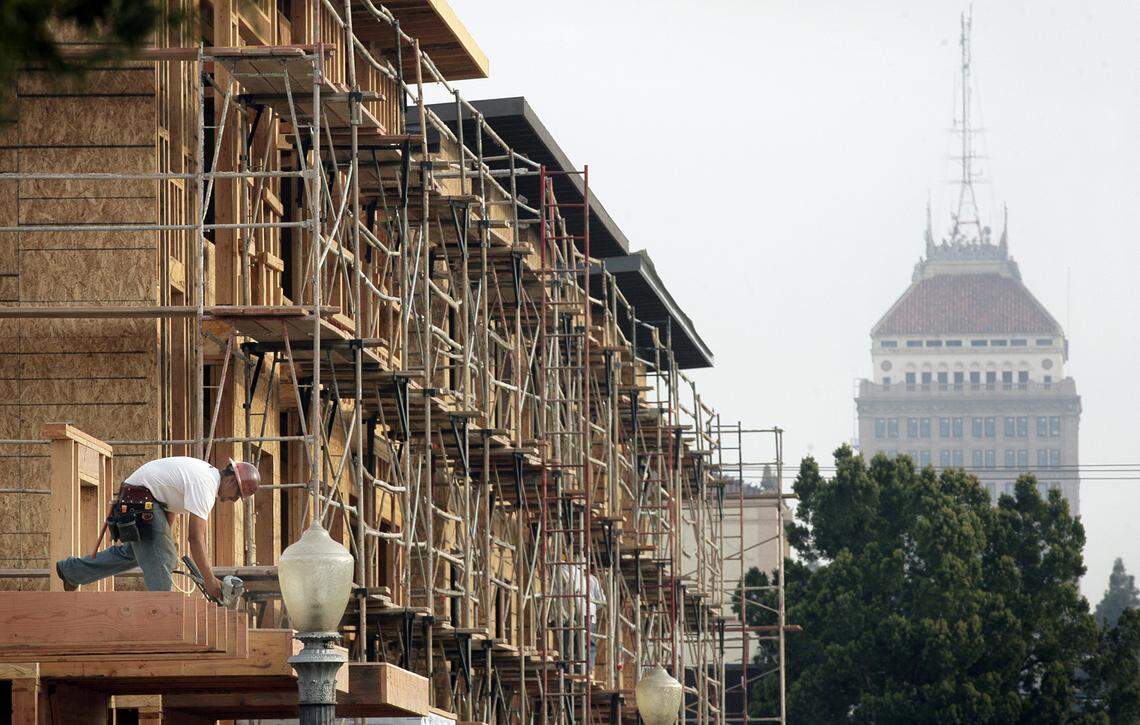 Construction crews work on a residential apartment building at Fulton and San Joaquin Street in downtown Fresno in this 2013 file photo. In the past two years, the city of Fresno has been home to a growing unhoused population, amidst rents that continue to climb and a shrinking number of people that can afford to become homeowners in the area.
