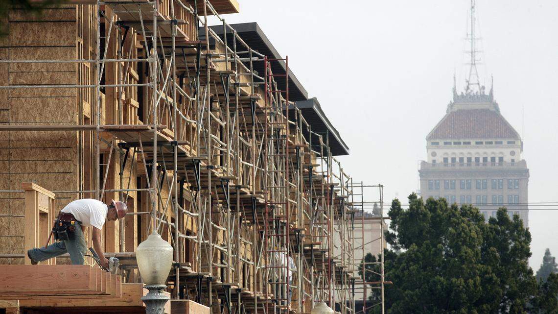 Construction crews work on a residential apartment building at Fulton and San Joaquin Street in downtown Fresno in this 2013 file photo. In the past two years, the city of Fresno has been home to a growing unhoused population, amidst rents that continue to climb and a shrinking number of people that can afford to become homeowners in the area.