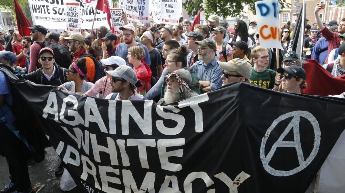 This Saturday, Aug. 12, 2017 image shows counter demonstrators holding a banner decrying white supremacists at the entrance to Emancipation Park in Charlottesville, Va.