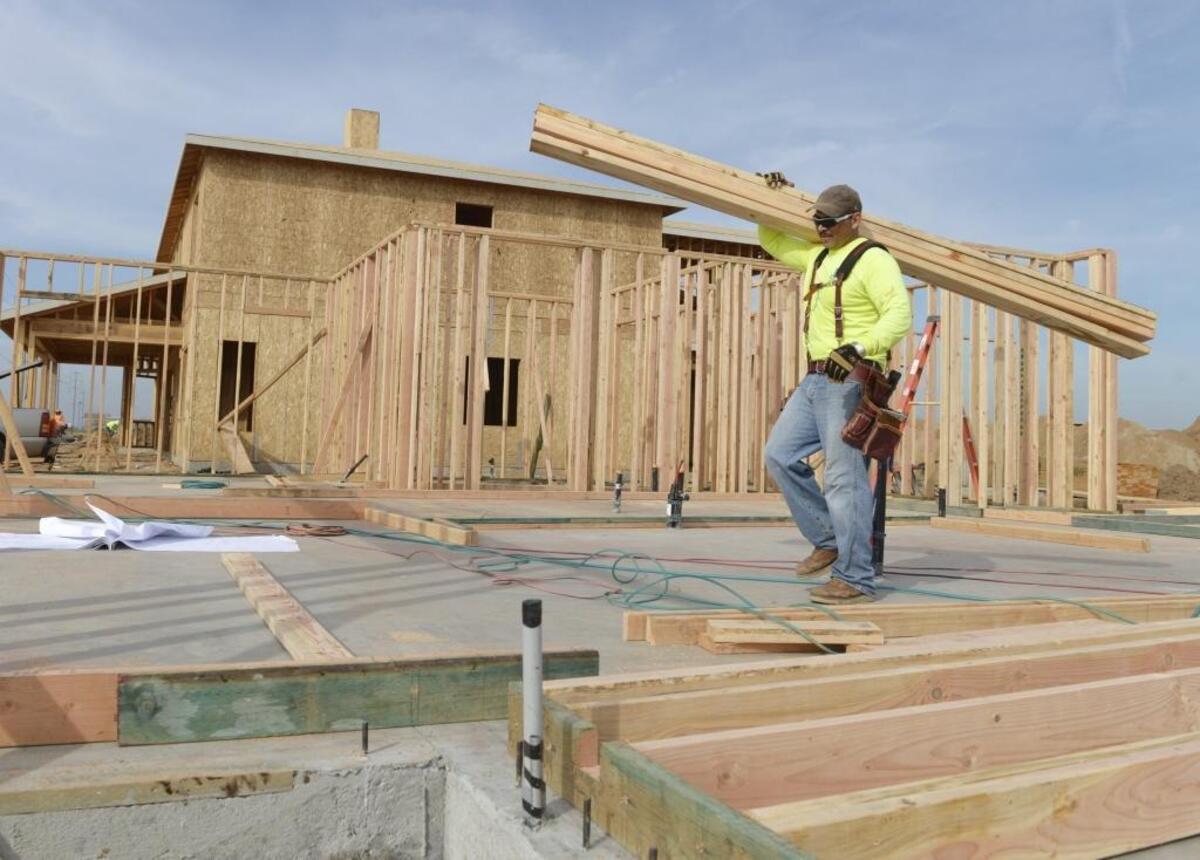 Humberto Guzman of Garcia Construction carries lumber while beginning construction on a home in the Gary McDonald Homes tract at Chestnut and Copper in the Copper River Ranch area Feb. 11, 2016.