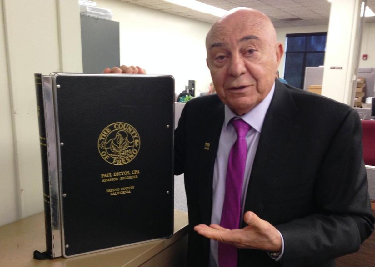 Fresno County Assessor-Recorder Paul Dictos in this 2023 file photo holds a bound volume of recorded documents, one of about 20,000 books of property records and other types of documents that are held by his office dating to the county’s origins in the 1850s.