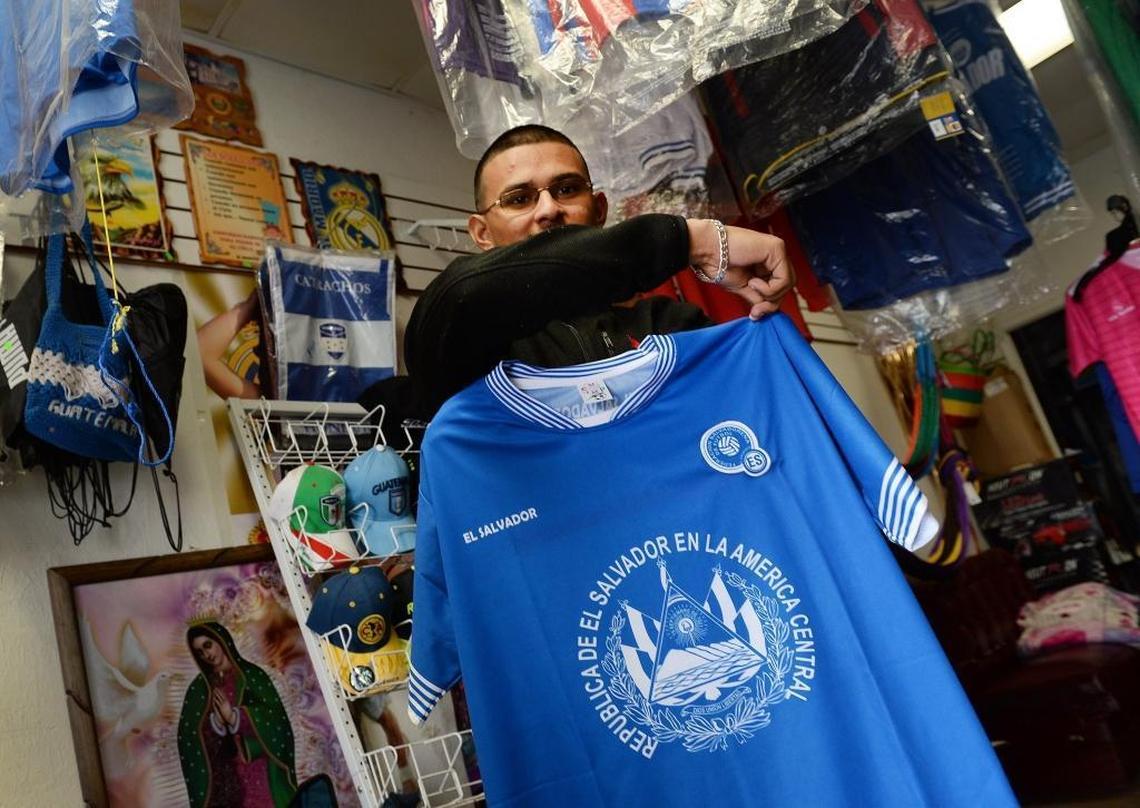 Kevin Rodas, a Salvadoran immigrant, holds up an El Salvador soccer team jersey at his shop, J&D Acceserorios, in Mendota on Friday, Jan. 12, 2018.