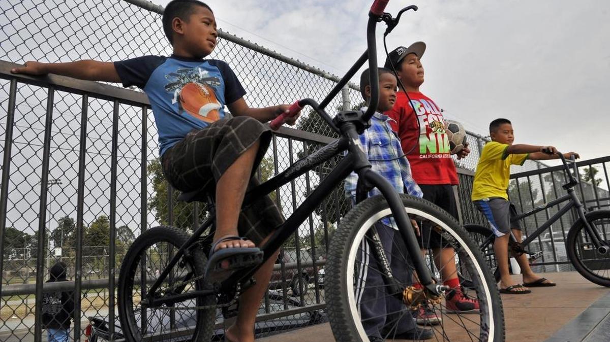 
Kids including Dominic Voeuth, 10, left, pause at the top of a ramp as they bike and ride scooters at Romain Playground’s skate park Saturday, Sept. 12, in Fresno. The skate park will be replaced with a newer one around the first of the year.
