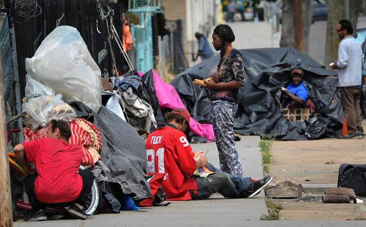 Homeless people congregate earlier this year on F Street near the Poverello House. A new city ordiance would make it illegal for the homeless to camp in tents or lean-to shelters on private or public property across Fresno.