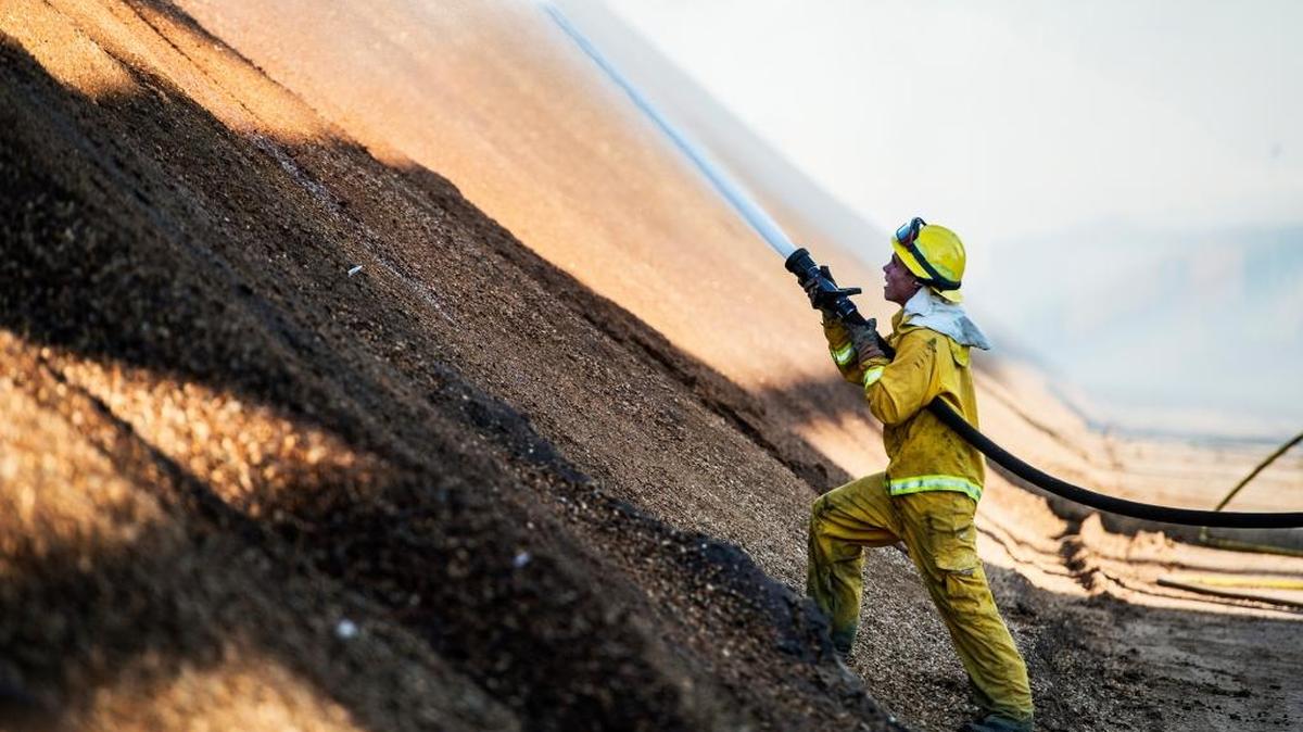 California Department of Forestry and Fire Protection, Merced County crews work to contain an almond hull fire at Minturn Huller Cooperative Inc. in Chowchilla, Calif., Monday, Nov. 16, 2015. According to Cal Fire officials, about 5,000 tons of almond hulls are burning.