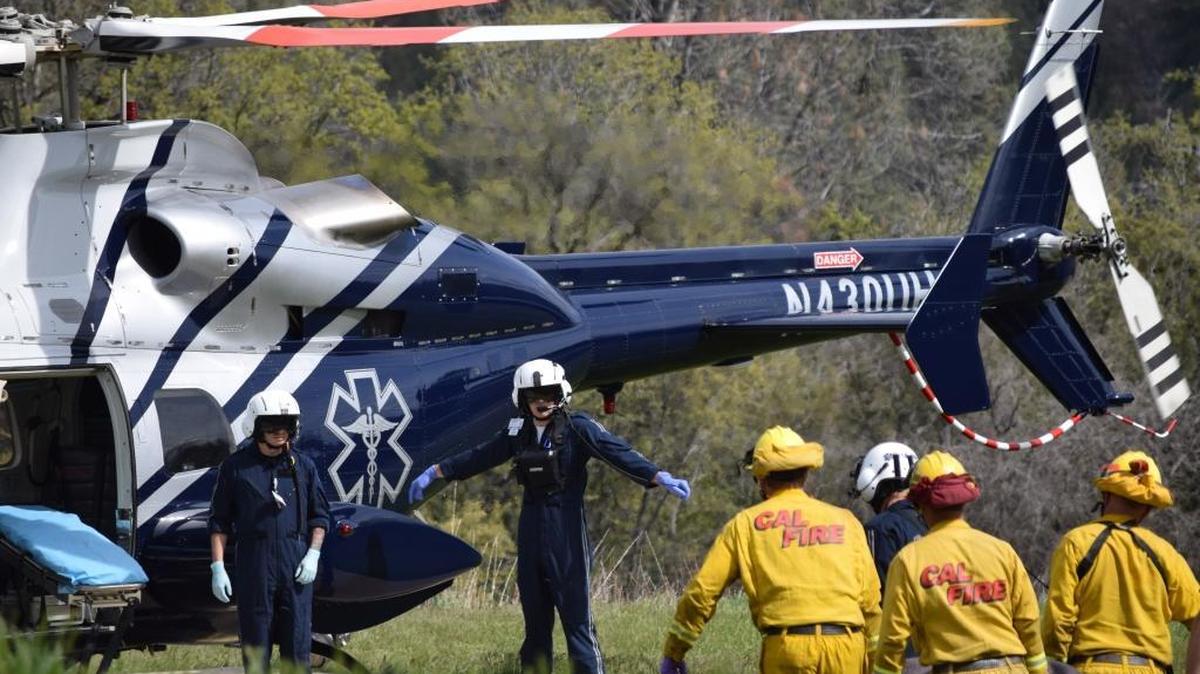 A woman rescued from Nelder Creek north of Oakhurst in Madera County is taken by rescue workers to a helicopter for transport to a hospital Thursday afternoon.