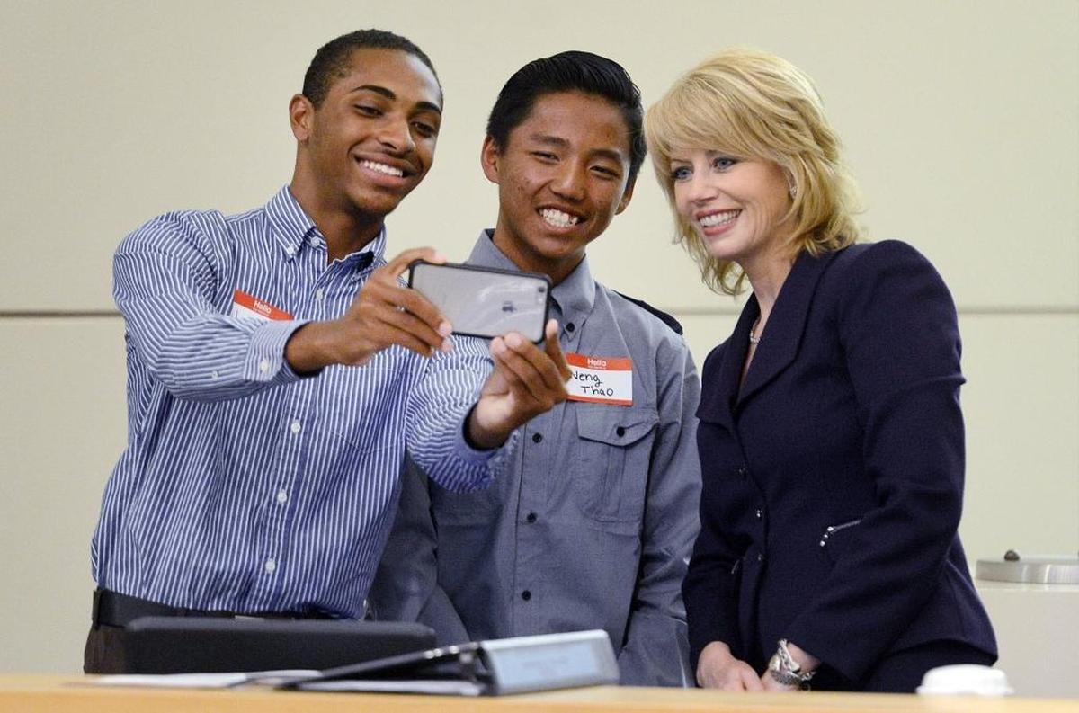 Mayor Ashley Swearengin poses for a selfie with Youth Commission Appointees Jason Phillips, left, and Neng Thao of the mayor’s commission after 16 new youth commissioners were sworn in during an April 2016 Fresno City Council meeting.