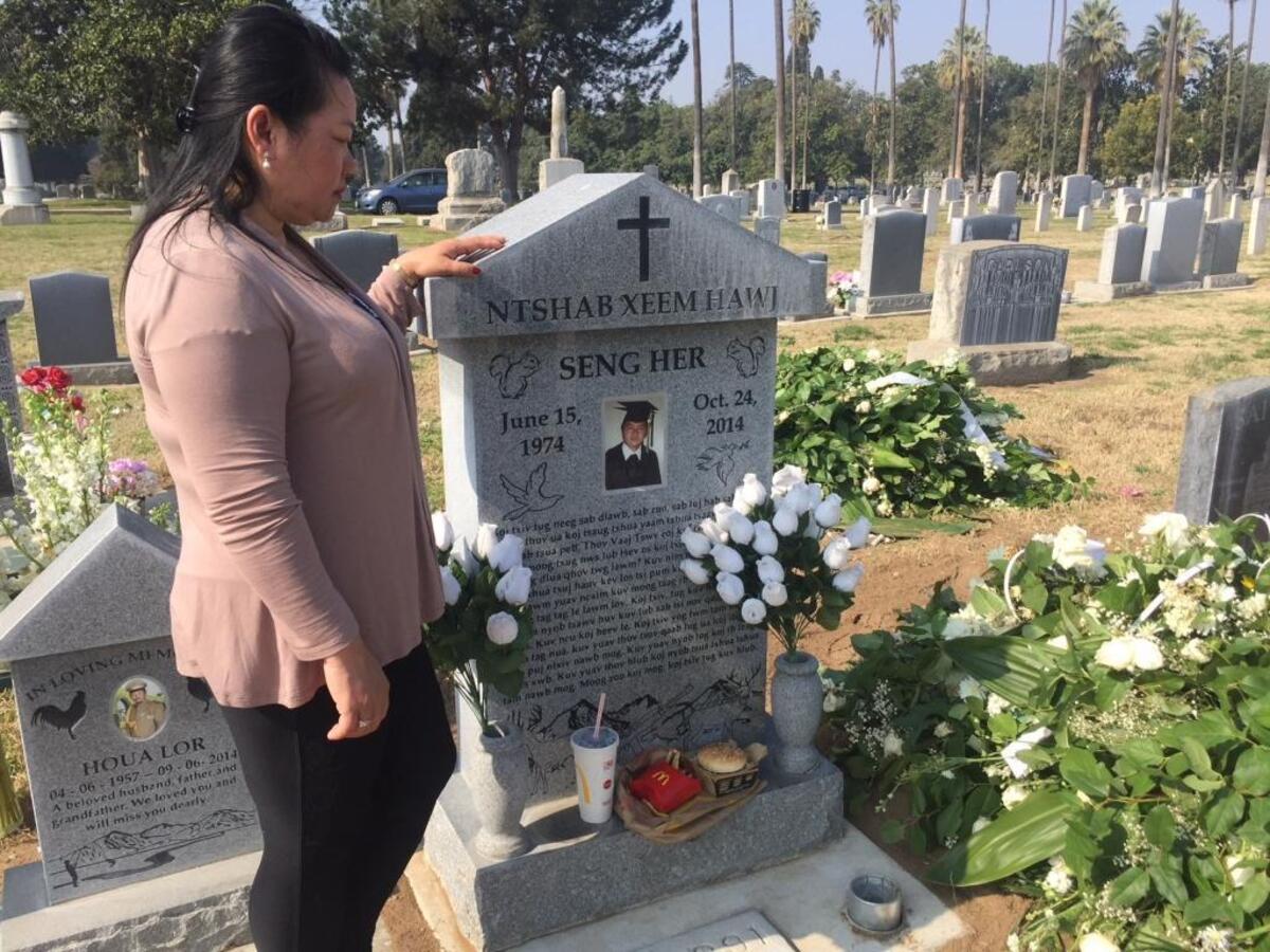 Youa Her of Fresno inspects the headstone of her late husband after it was moved back into position at Mountain View Cemetery in Fresno, California, on Feb. 6, 2018.