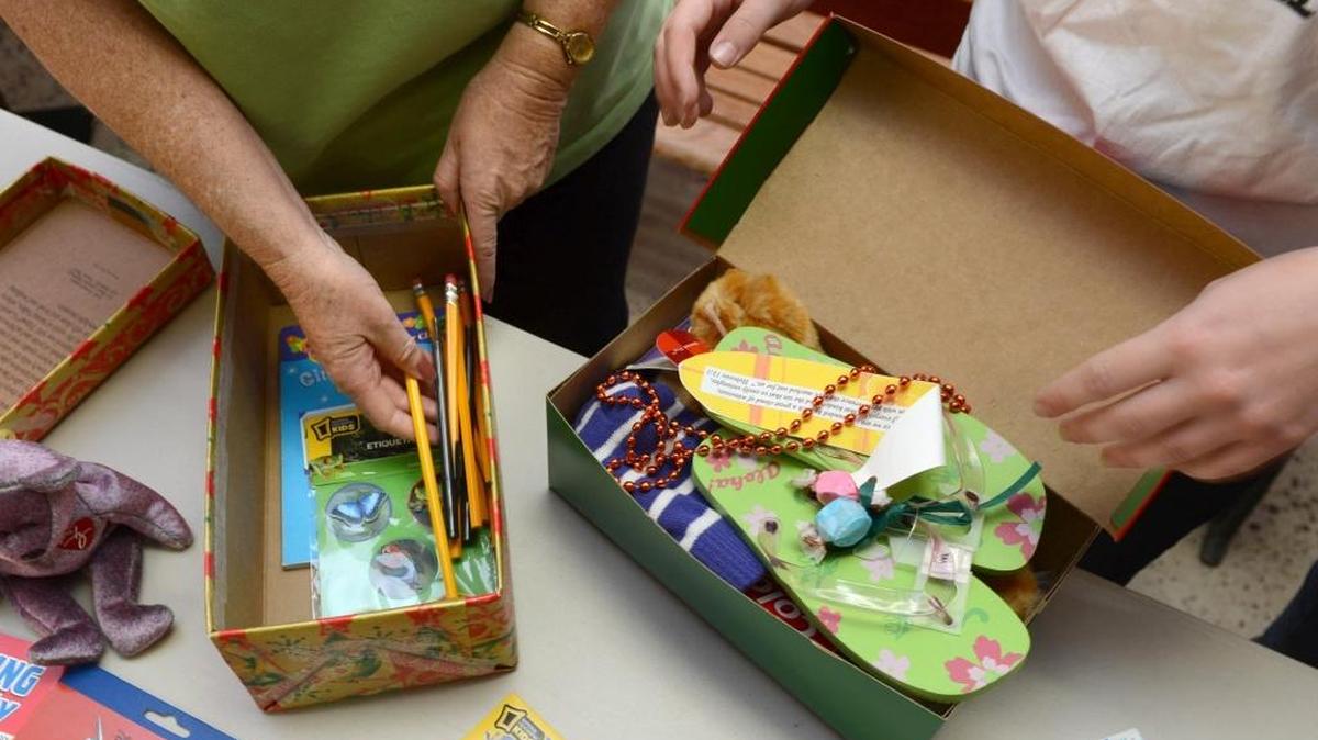 Operation Christmas Child volunteers pack a shoebox with gifts and supplies in this 2012 photo.