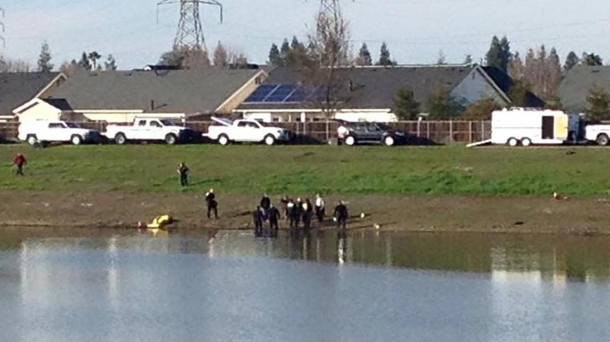 Fresno County sheriff’s dive team works to recover a body from a pond in northwest Fresno on Tuesday, Jan. 12, 2015.