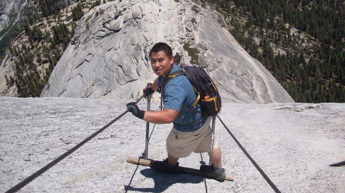 A hiker stops to pose for a photo before making his way down the infamous cables section on Half Dome in Yosemite National Park.