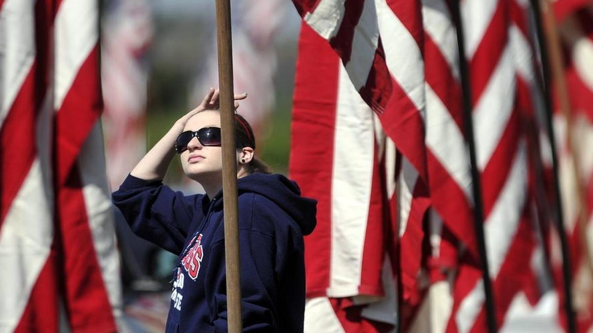 
Katie Blankinship searches for her great-grandfather Bill Stiggins' name on flags lining the roads at the 52nd Annual VFW Memorial Day Service held at Fresno Memorial Gardens. Katie said her great-grandfather served in the United States Army and died in World War II.
