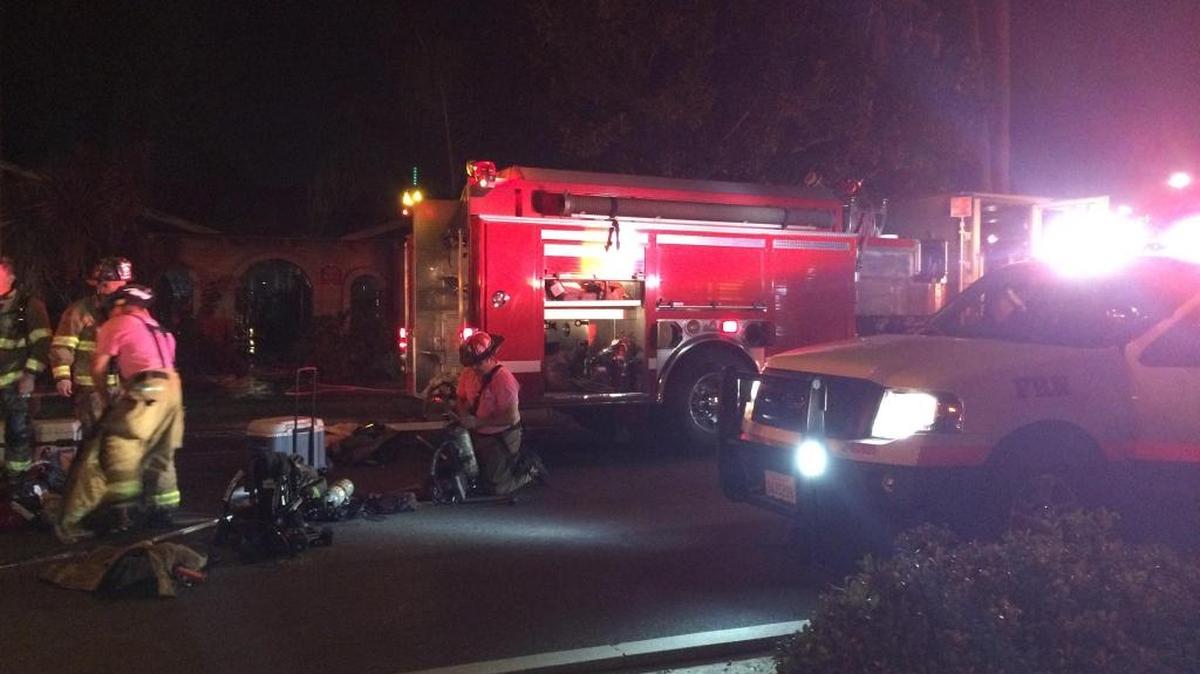 Firefighters mop up after battling an apartment blaze in north Fresno on Friday night, Oct. 30, 2015.