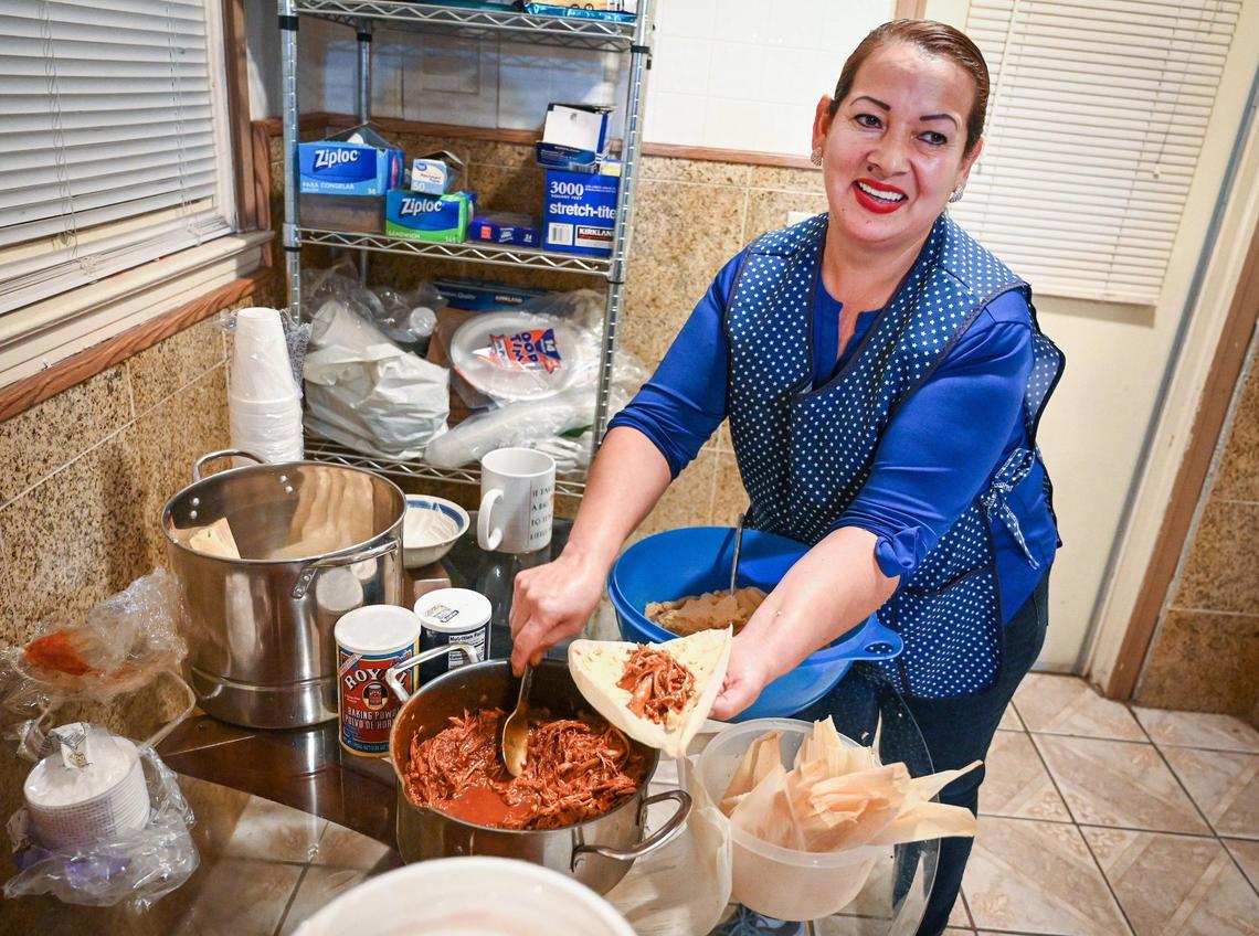 Cristina Leon smiles while making tamales in her son Ruben’s kitchen in Fresno on Friday, Dec. 17, 2021. Ruben Vasquez has been making TikTok videos of his mother’s cooking, generating a following of more than 55,000.