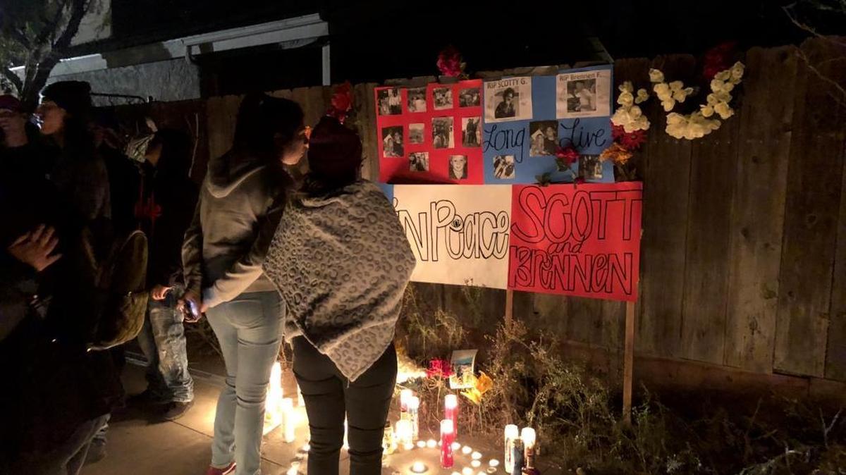 Yvette Gomez, right, stands in front of posters and candles during a vigil for Scott Alex Gaffney and Brennen Julian Fairhead on Friday, Dec. 15, 2017. Gaffney and Fairhead, both 21, were shot and killed a day earlier in Fresno.