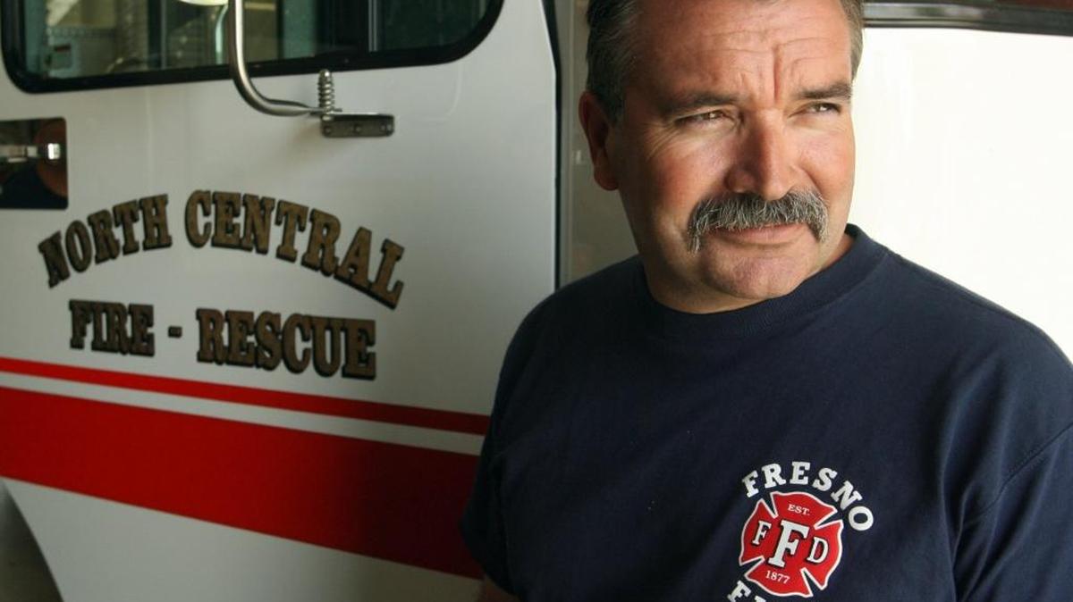 This 2007 photo shows North Central Fire Protection District captain Matt Sullivan in a Fresno City Fire Department shirt beside a North Central Fire Protection District truck.