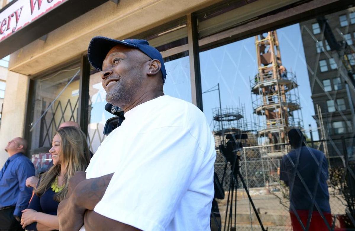Franklin Brown of Fresno watches as the Fulton Mall clock tower, reflected in the window, is lowered into its new location about 30 feet to the southwest from its old spot in the middle of Fulton and Mariposa streets on Tuesday, July 18, 2017. As a child, Brown and his grandfather watched the clock tower being put into place in 1964.