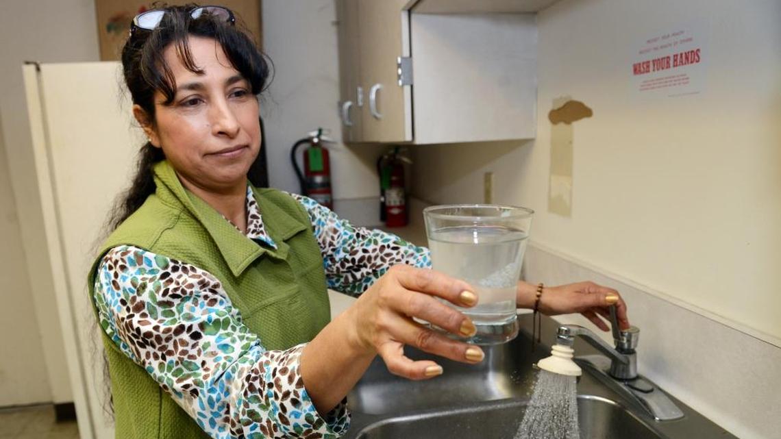 Isabel Solorio shows a glass of cloudy water in the Lanare community center in 2013. Lanare is a Fresno County town of 600 where arsenic-tainted water came out of the tap until new wells were built with state help.