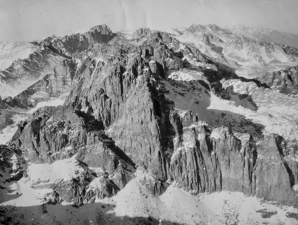 Photograph taken by Orland Bartholomew showing the rugged terrain he traversed on his way to becoming the first known person to do a solo winter ascent of Mt. Whitney, the rocky peak at upper left. His caption reads: “Northward from summit of Mt. Langley. Mt. Whitney, Mt. Williamson on skyline, Jan. 1929.”