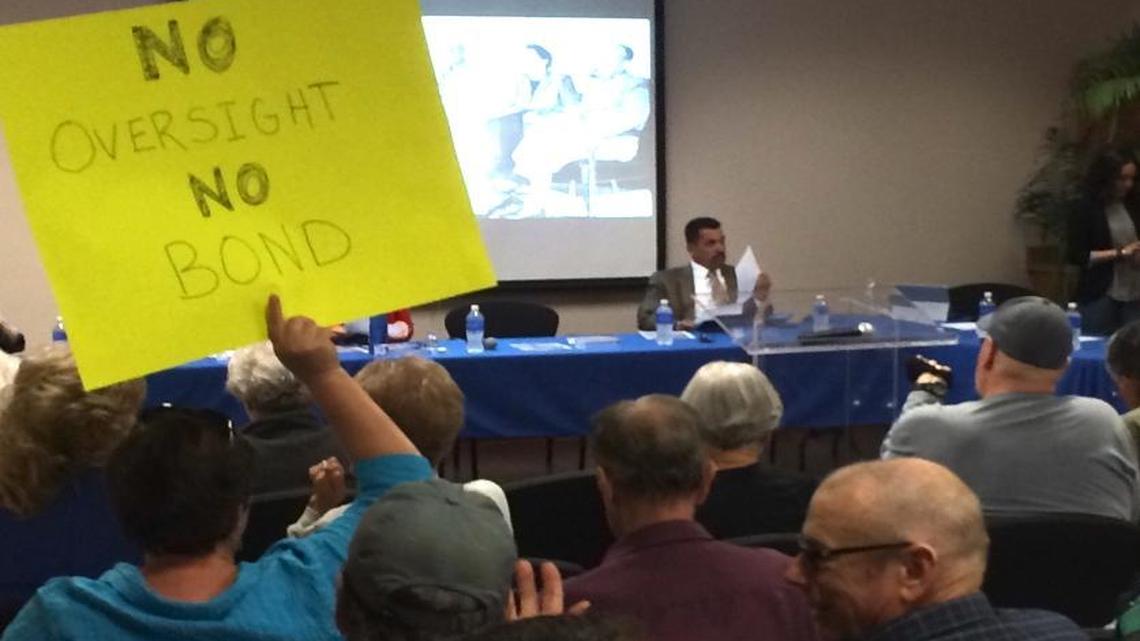 An opponent of a proposed bond measure holds a sign at the Monday, May 2 meeting of the Tulare Local Health Care District board of directors.