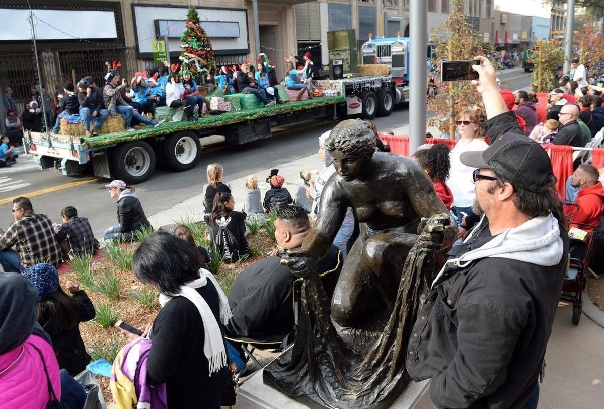 The Renoir washerwoman sculpture mixes in among the crowd at Fulton and Mariposa streets as the 88th annual Downtown Fresno Christmas Parade moves along the newly opened Fulton Street on Saturday, Dec. 2, 2017.