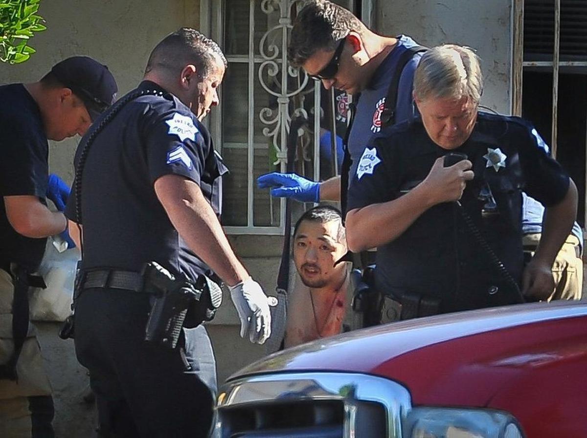 A man wounded in the shoulder at 5267 E. Hammond Ave. in east-central Fresno on Tuesday morning, June 6, 2017, is tended by Fresno Fire Department EMTs as police officers work the scene. Police said four people were shot; three are dead.