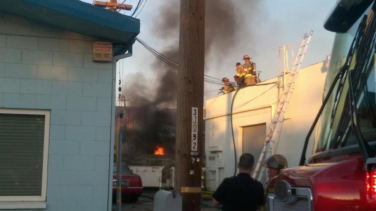 Firefighters battle a blaze Wednesday evening at Clovis Body and Paint.