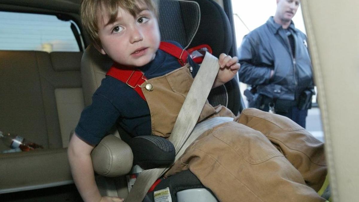 Zander Nichols, 4, buckles himself into his car seat in this file photo. Assuring that children are properly restrained is a key during holiday travel.