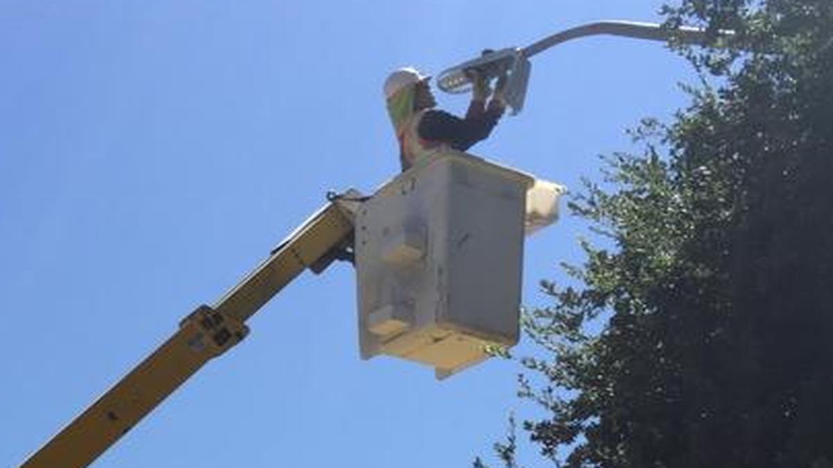 A worker installs an LED bulb in a Clovis streetlight. Nearly 8,000 lamps will be converted to LED within the city, PG&E officials said.
