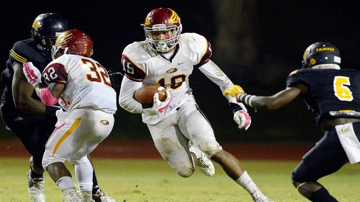 Clovis West’s Caleb Kelly, center, looks for a hole on a run against Edison in their game at McLane High stadium Oct. 2.