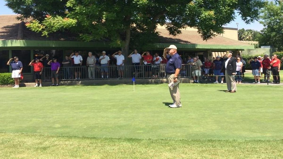 A crowd salutes the flag at the opening ceremony of the third annual American Legion Memorial Day Golf Tournament at Belmont Country Club on Thursday, May 26.