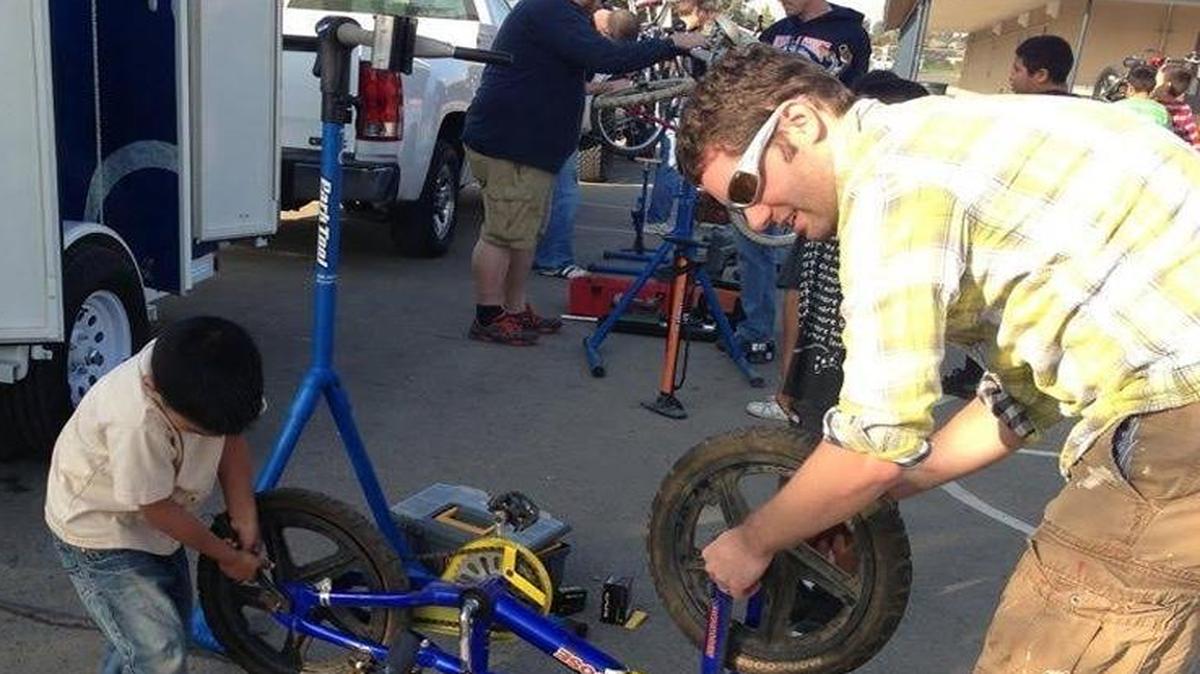 Volunteers at a Saturday morning bike clinic teach children to repair their own bikes.