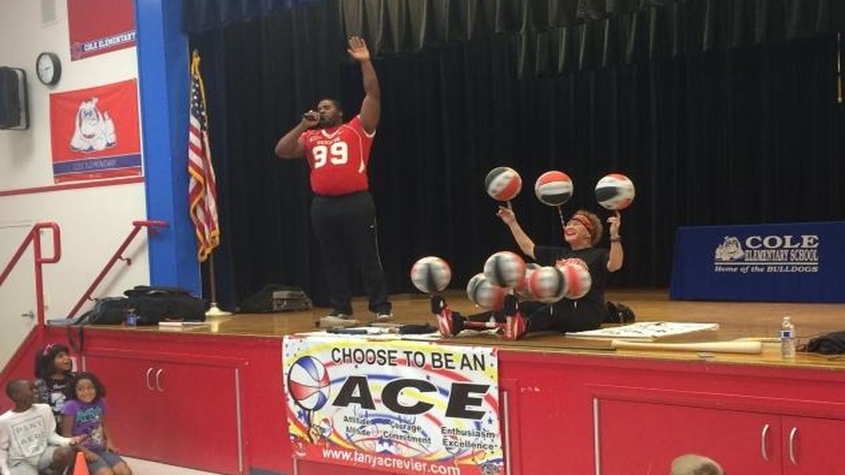 Professional basketball handler Tanya Crevier spins 10 basketballs at once on the Cole Elementary School stage to demonstrate focus and persistence during a Champions for Tomorrow assembly.