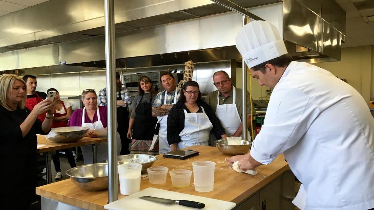 About 20 participants gathered around Chef Christian Romeo as he demonstrated how to prepare the pizza dough on Friday, Aug. 26 at Institute of Technology in Clovis.