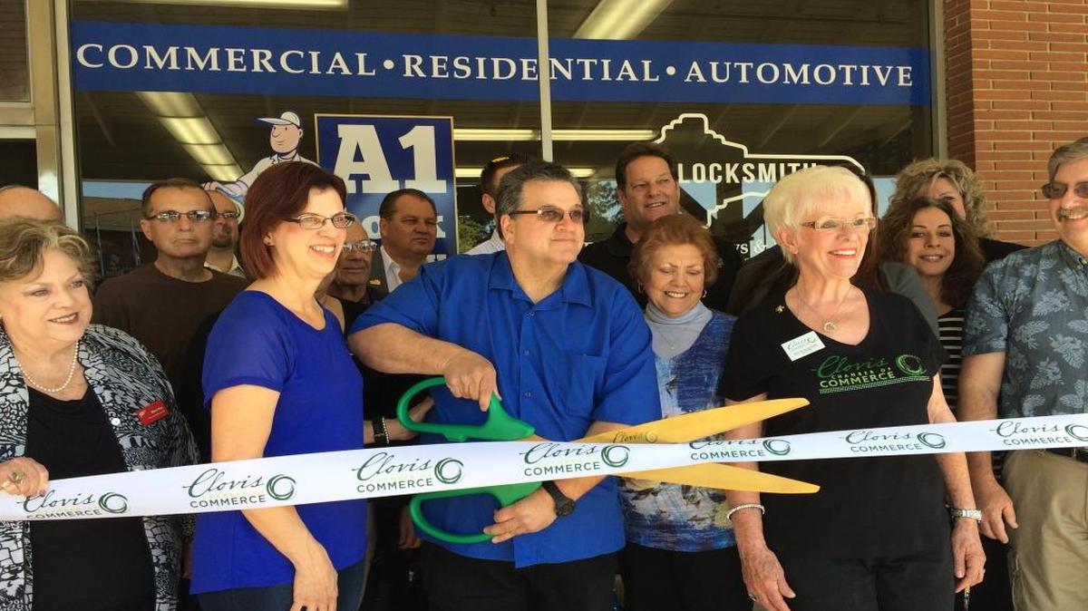 Terri and Martin Hinshaw, in blue, cut the ribbon during a Clovis Chamber of Commerce ceremony marking A1 Lock & Key’s first year in its brick and mortar establishment at 515 4th Street in Old Town Clovis.